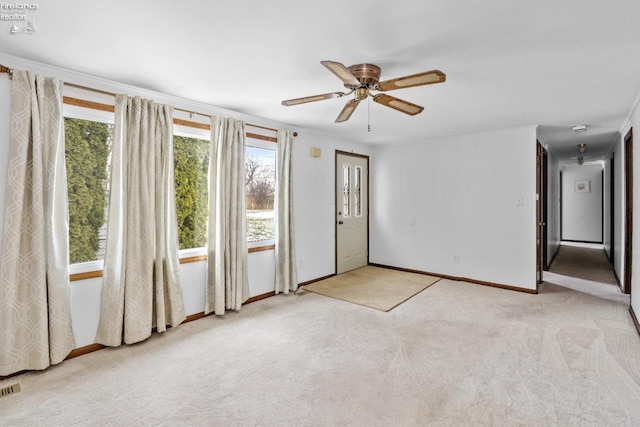 unfurnished room with ceiling fan, light colored carpet, and ornamental molding