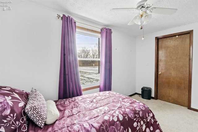 bedroom featuring light carpet, ceiling fan, and a textured ceiling