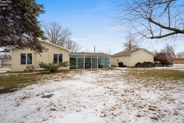 snow covered property with a sunroom