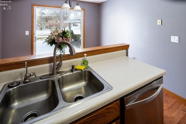 kitchen with sink, hardwood / wood-style flooring, hanging light fixtures, and dishwasher