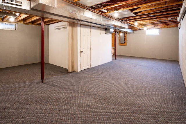 basement with electric panel, an AC wall unit, and dark colored carpet