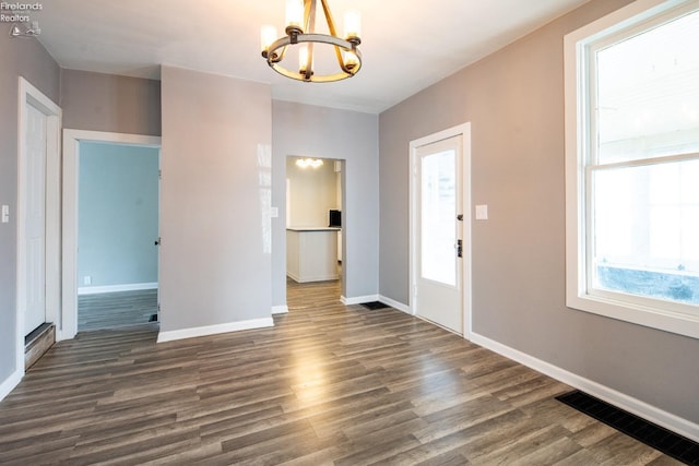 entryway with dark hardwood / wood-style floors and a chandelier