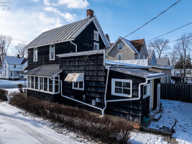 view of snowy exterior featuring a sunroom