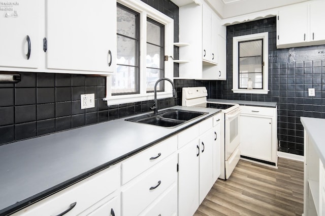 kitchen with white cabinetry, sink, light hardwood / wood-style floors, and white range with electric cooktop