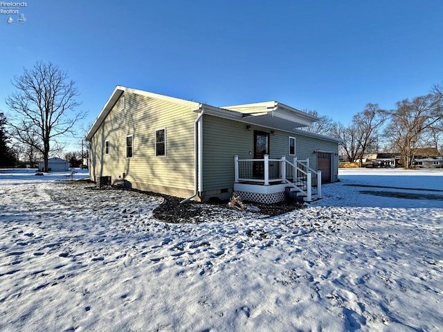 snow covered property with a garage