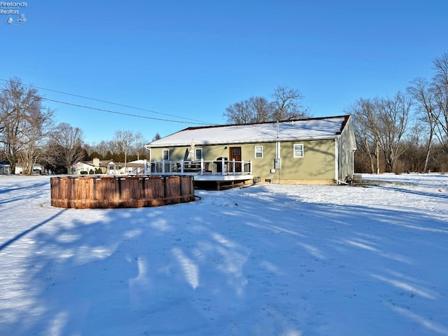 snow covered house with a deck