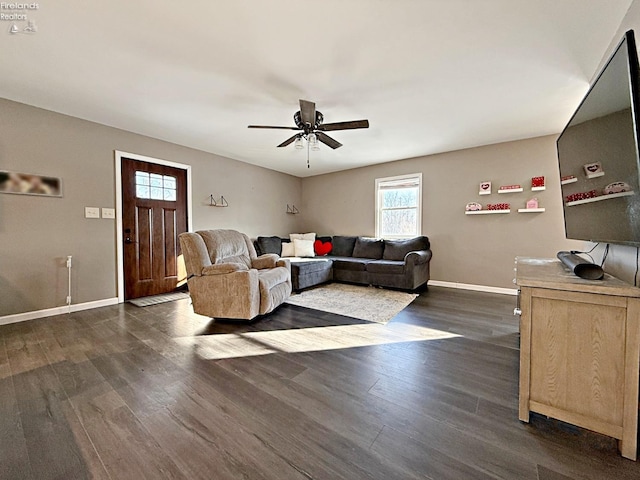 living room featuring dark wood-type flooring and ceiling fan