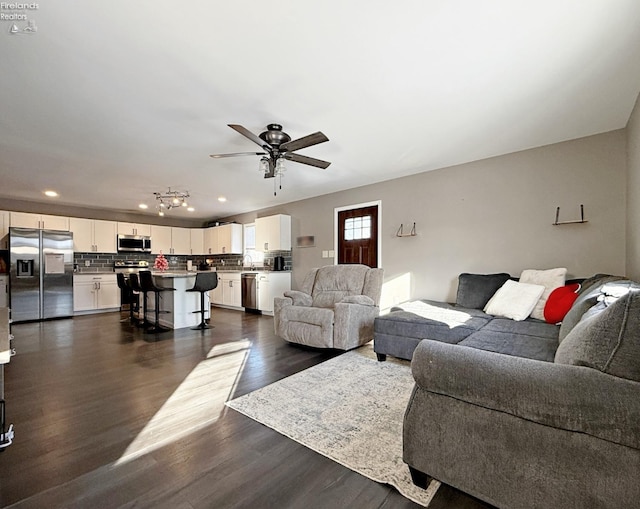 living room with ceiling fan and dark hardwood / wood-style flooring