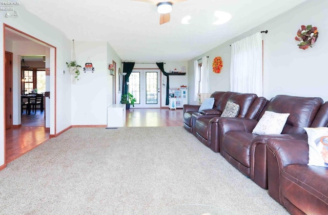 living room featuring carpet flooring, ceiling fan, and french doors