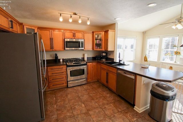 kitchen with appliances with stainless steel finishes, a textured ceiling, kitchen peninsula, ceiling fan, and lofted ceiling