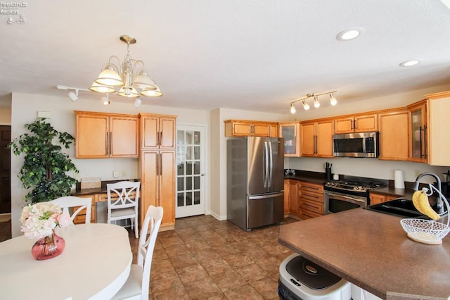 kitchen featuring sink, decorative light fixtures, a notable chandelier, and appliances with stainless steel finishes