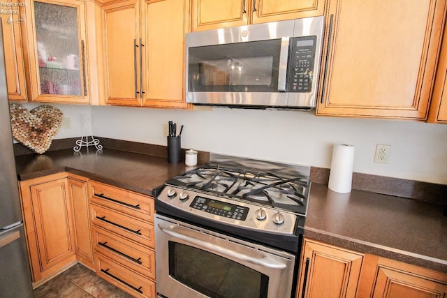 kitchen featuring dark tile patterned floors and stainless steel appliances