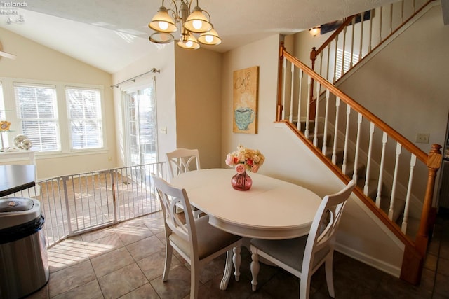 tiled dining area with lofted ceiling and a chandelier