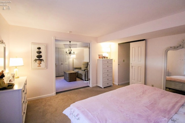 bedroom with light colored carpet and a notable chandelier