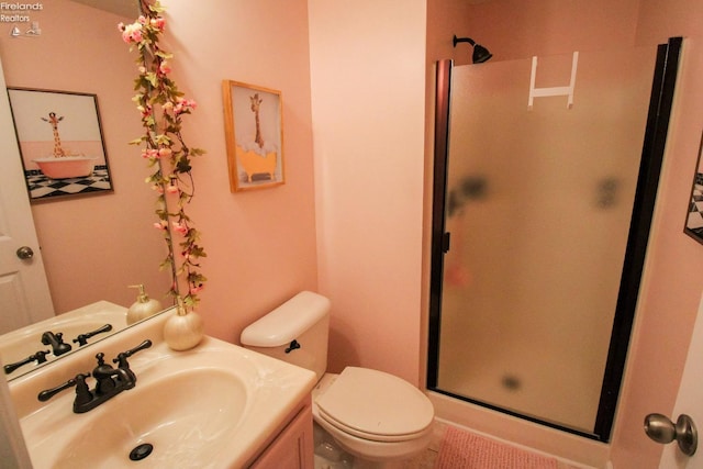 bathroom featuring toilet, vanity, and walk in shower