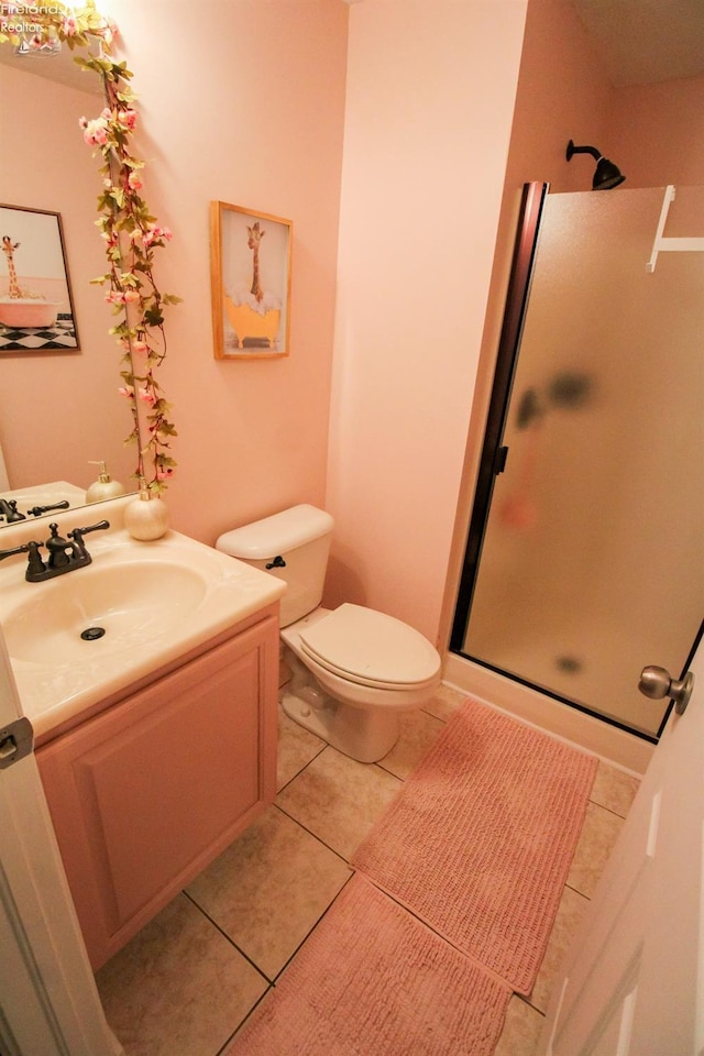 bathroom featuring vanity, toilet, an enclosed shower, and tile patterned flooring