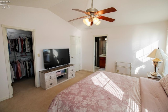 bedroom featuring ceiling fan, vaulted ceiling, light carpet, and ensuite bath