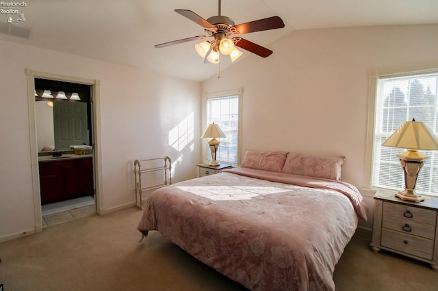 bedroom featuring ceiling fan, ensuite bath, multiple windows, and carpet