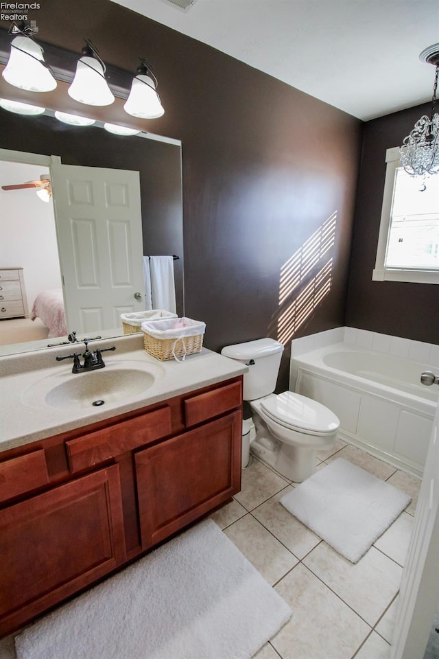 bathroom with a tub to relax in, toilet, vanity, and tile patterned flooring