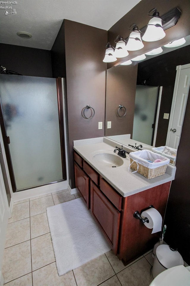 bathroom featuring an enclosed shower, vanity, toilet, and tile patterned flooring