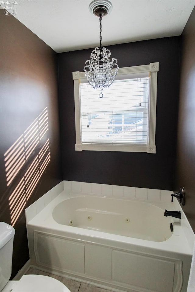 bathroom featuring a notable chandelier, toilet, tile patterned flooring, and a bathing tub