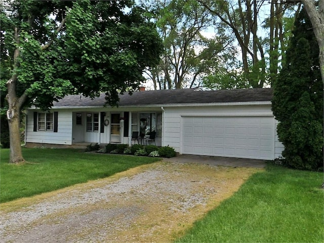 single story home featuring a garage, a front yard, and a porch