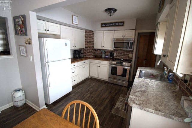 kitchen with sink, dark wood-type flooring, stainless steel appliances, and white cabinets