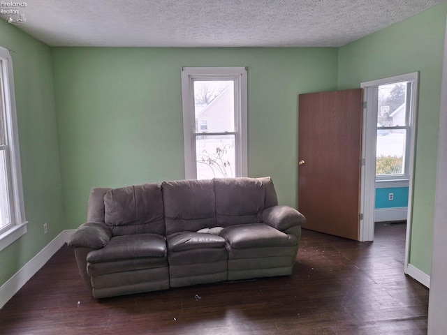 living room with dark wood-type flooring and a textured ceiling