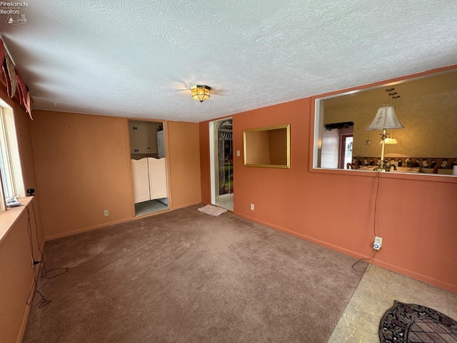 unfurnished room featuring carpet and a textured ceiling