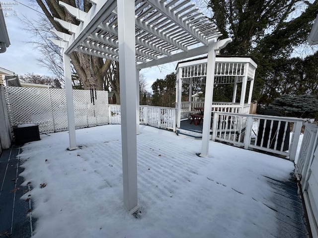 snow covered deck featuring a pergola