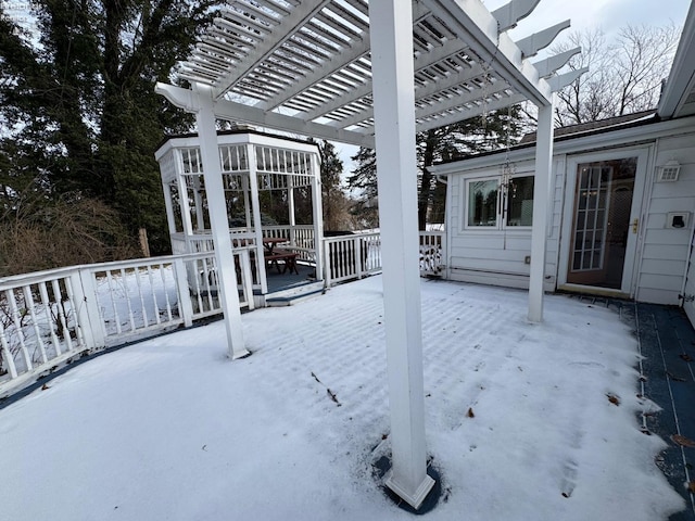 snow covered patio featuring a deck and a pergola