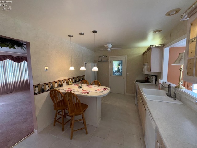 kitchen with decorative light fixtures, sink, white appliances, and light tile patterned floors