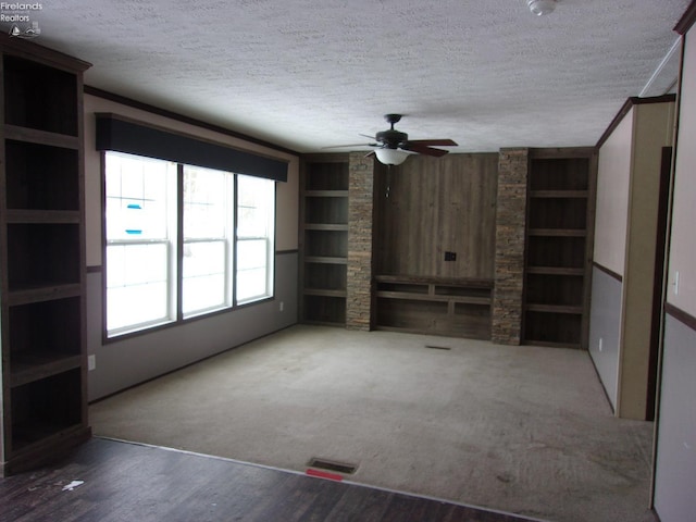 unfurnished living room with ceiling fan, hardwood / wood-style floors, built in features, and a textured ceiling