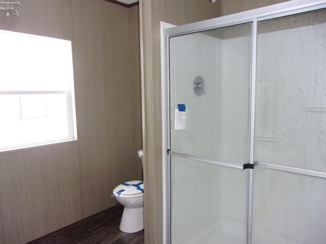 bathroom with walk in shower, wood-type flooring, and toilet