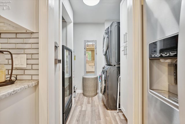 interior space featuring stacked washer and dryer and light hardwood / wood-style flooring