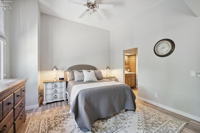 bedroom featuring high vaulted ceiling, light hardwood / wood-style floors, ceiling fan, and ensuite bathroom