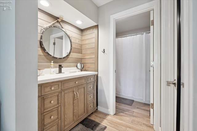 bathroom with vanity and wooden walls