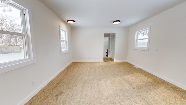 spare room with plenty of natural light and light carpet