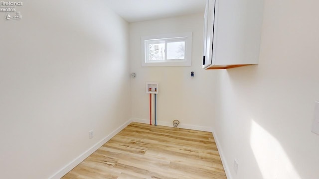 laundry area featuring washer hookup, cabinets, and light wood-type flooring