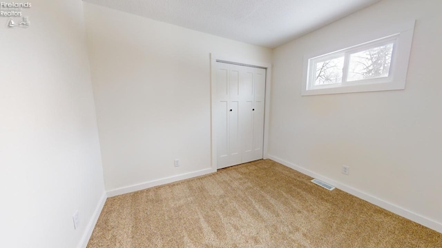 unfurnished room featuring light colored carpet