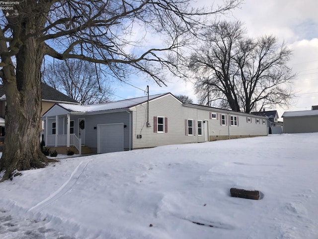 view of snow covered exterior featuring a garage