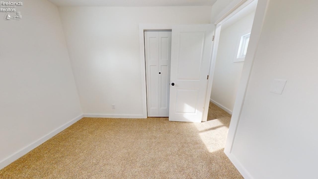 unfurnished bedroom featuring light carpet