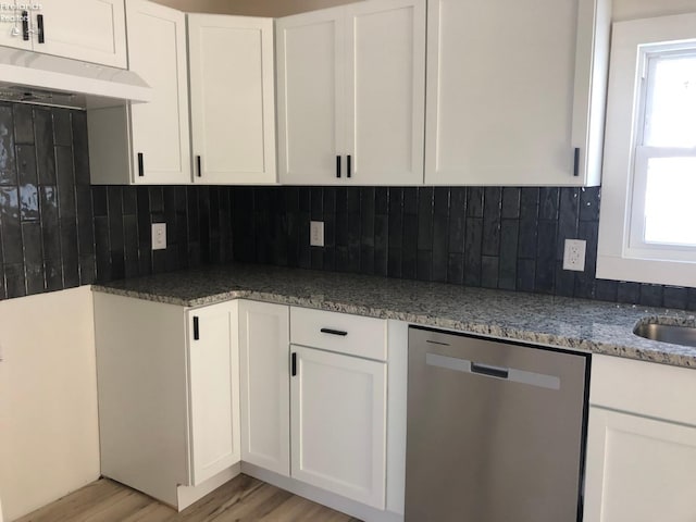 kitchen with white cabinets, backsplash, light hardwood / wood-style flooring, and dishwasher