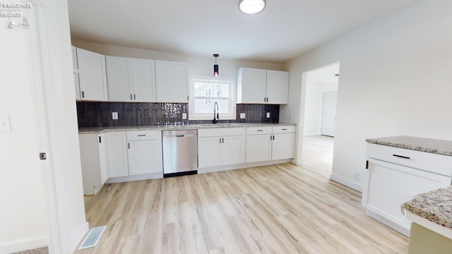 kitchen with white cabinetry, dishwasher, sink, and light hardwood / wood-style flooring