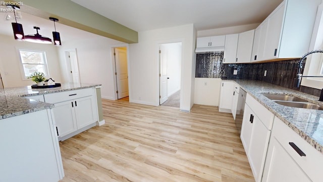 kitchen featuring decorative light fixtures, light stone countertops, sink, and white cabinets