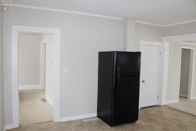 kitchen featuring black refrigerator, light colored carpet, and crown molding