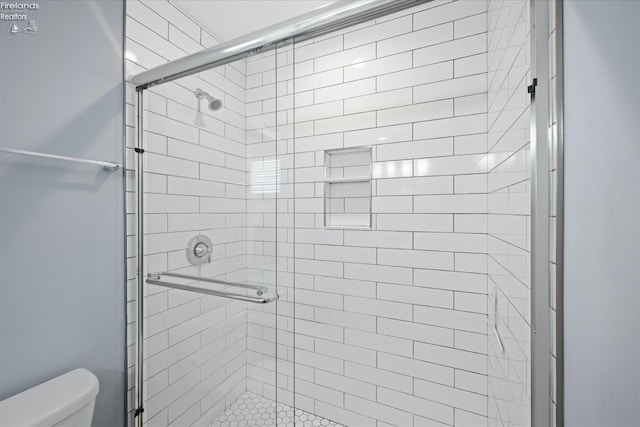 bathroom featuring walk in shower and toilet