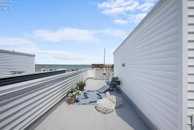 view of patio / terrace featuring a balcony and a water view