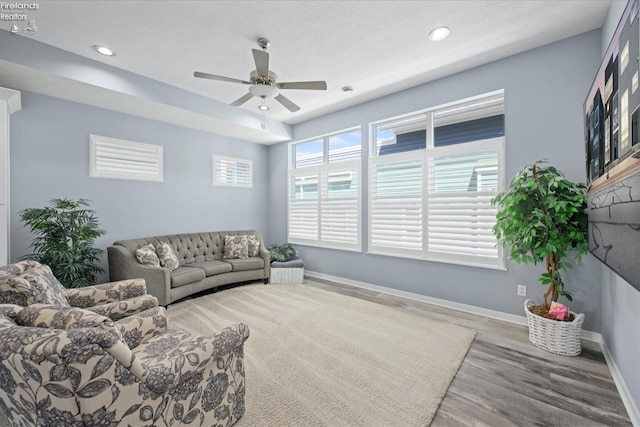 living room with wood-type flooring and ceiling fan