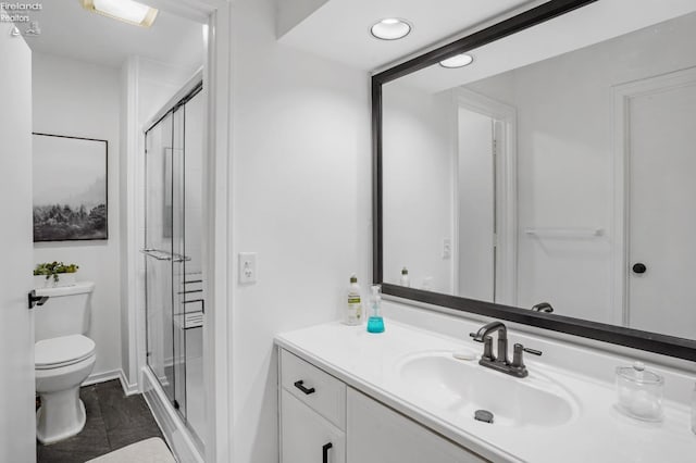 bathroom with vanity, an enclosed shower, and toilet